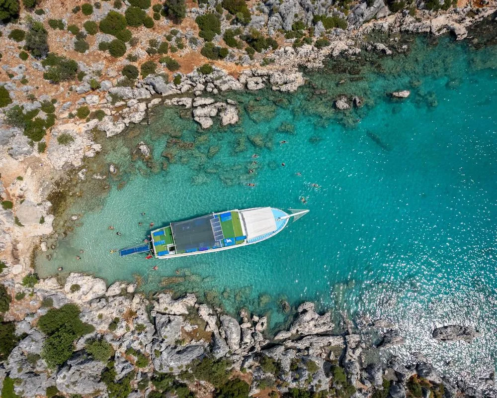 Aerial view of a boat anchored in crystal-clear waters during a coastal boat trip in Oludeniz, Turkey.