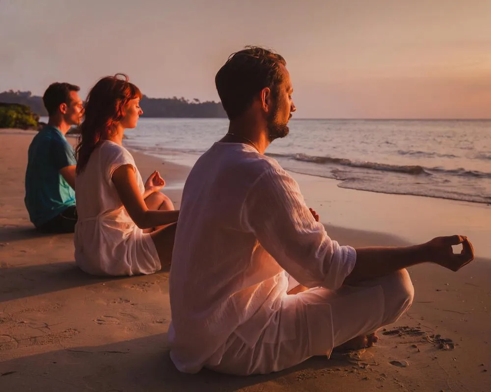 Group meditating peacefully by the ocean during sunset in Oludeniz.