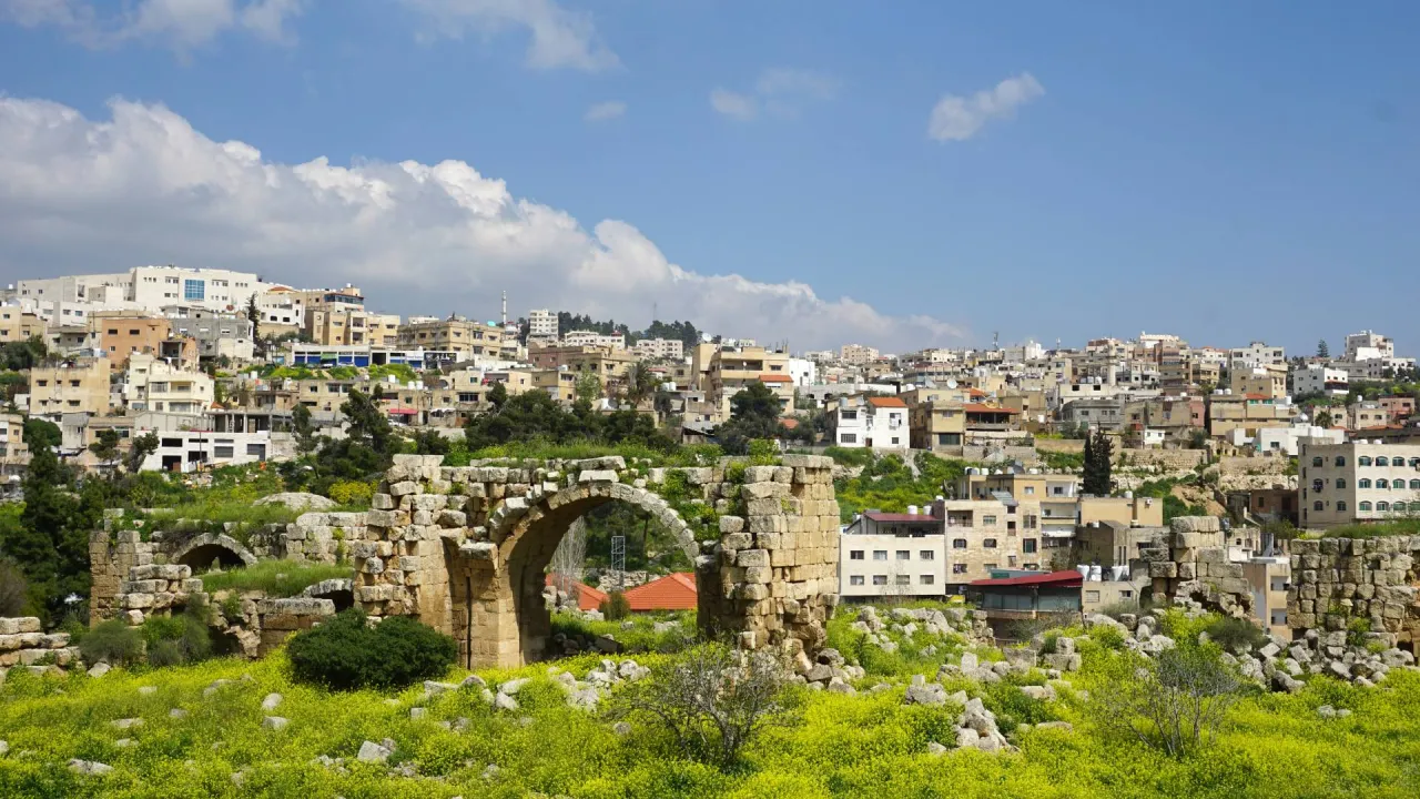 Ancient stone arches and ruins overlooking the modern city of Jerash